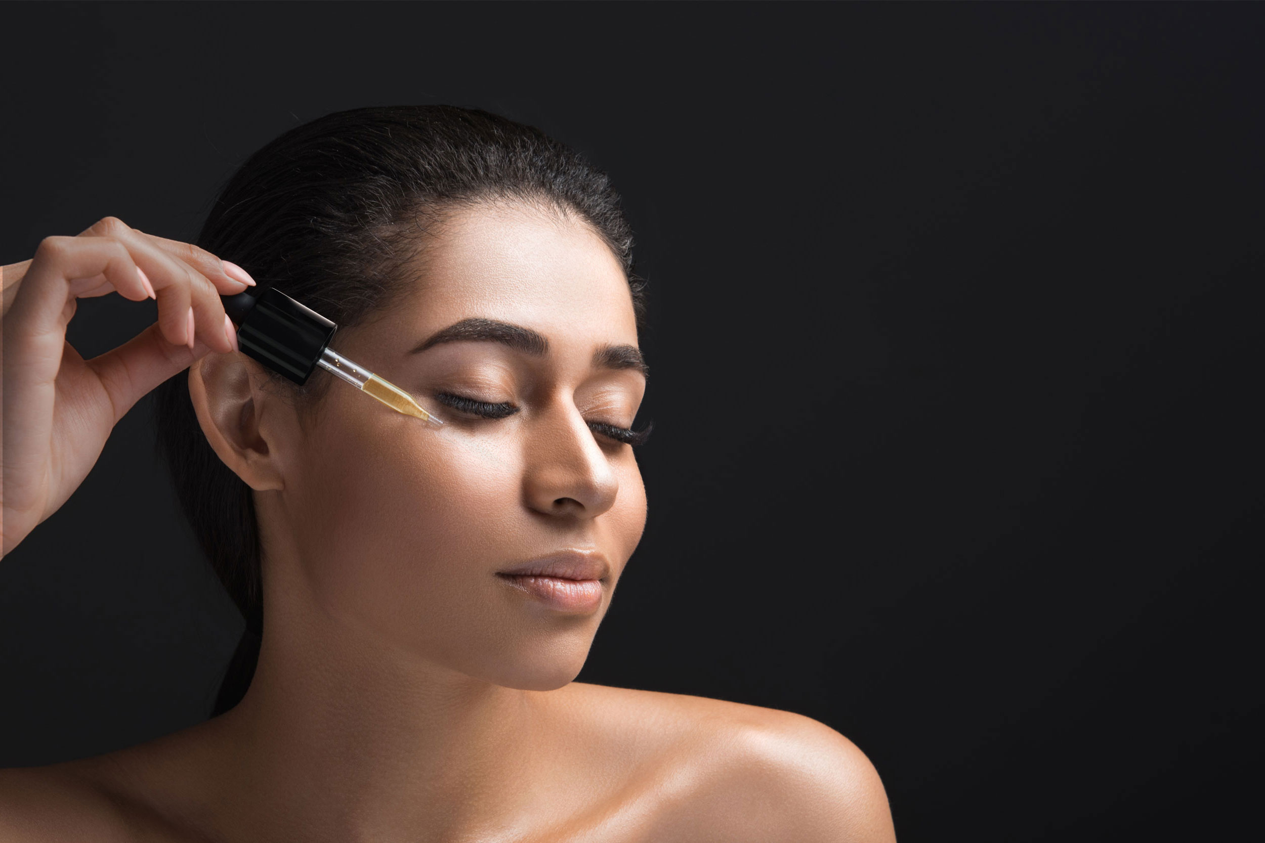 Woman applying the beU Jojoba Anti-Aging Serum